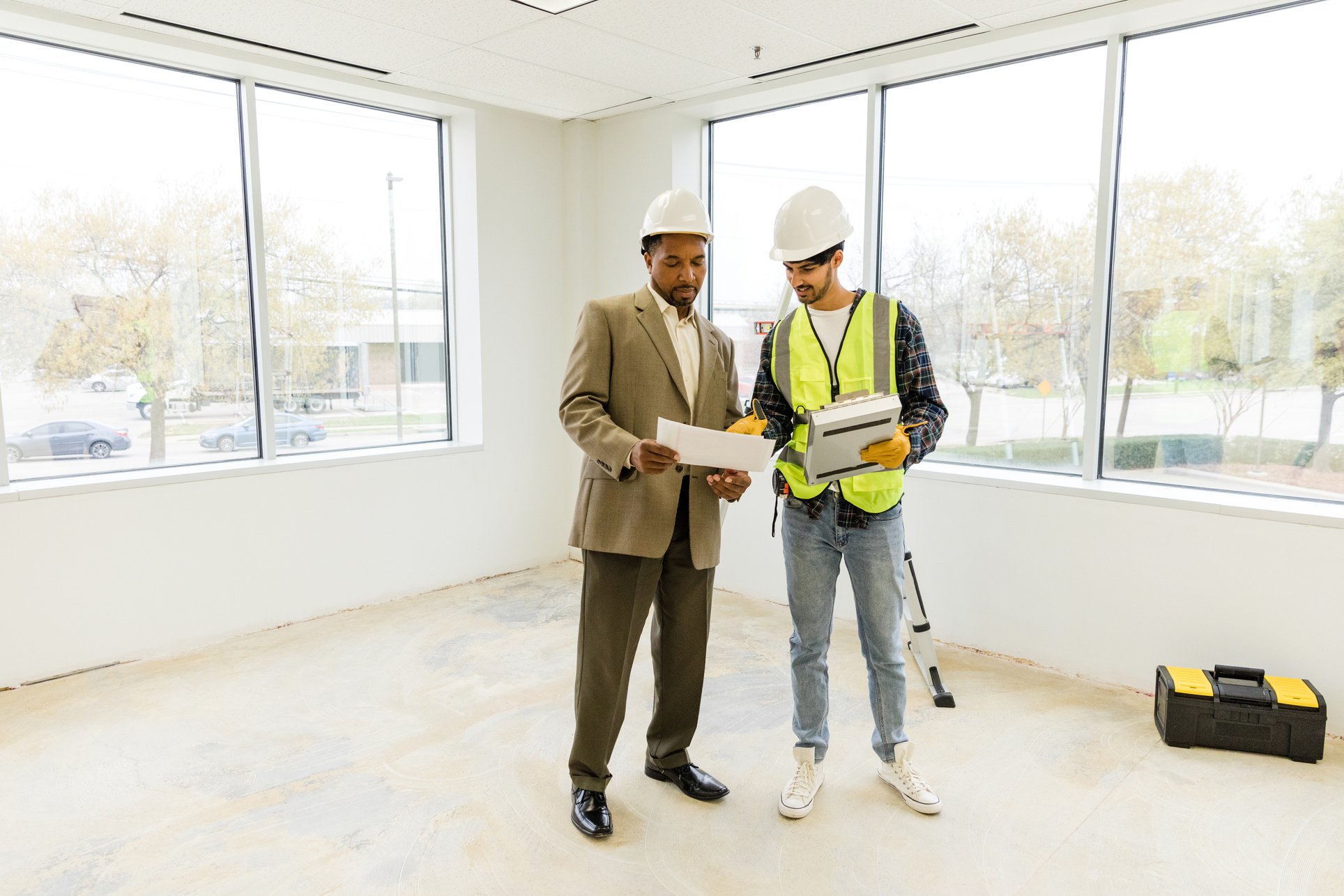 Mature male owner and young foreman discuss punch list items